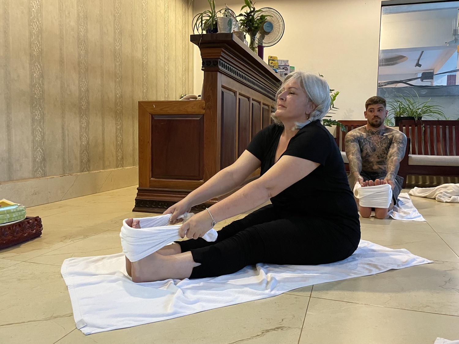 A student easing into a gentle seated forward fold with support
